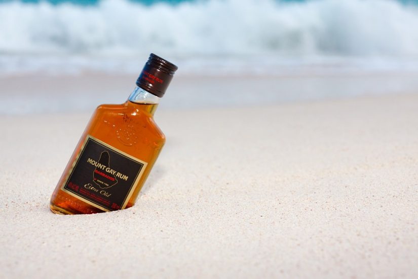 Bottle of Rum Bottle of mount gay rum stuck in the sand next to a rum shack in barbados