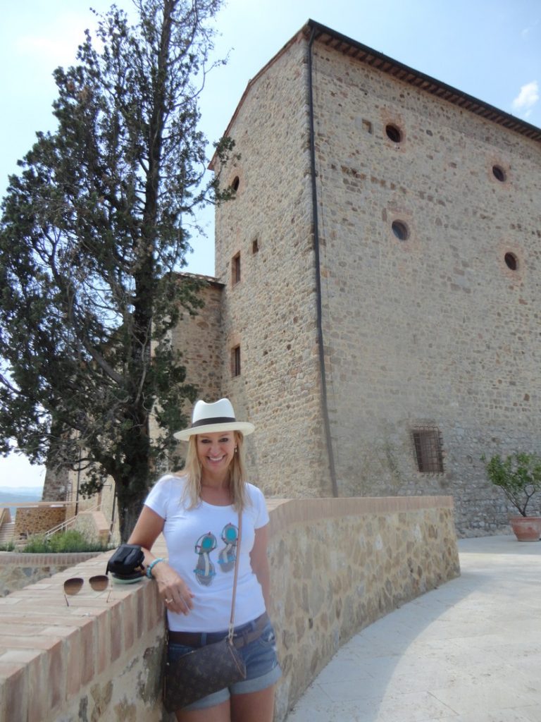 Alex standing in front of a classically designed building in Tuscany
