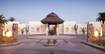 A powedery white sand beach in Mexio with a small rowing boat moored just off of the shore.