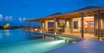 Villa Nina overlooking a moored private boat in the ocean at St Barts.